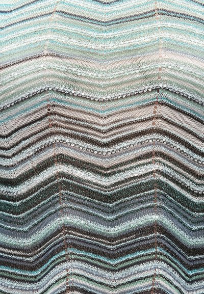 Πλεκτό ύφασμα με σχέδιο ζιγκ-ζαγκ και εναλλασσόμενες σειρές γκρίζου, λευκού, μαύρου και τιρκουάζ νήματος που δημιουργούν υφασμένους οριζόντιους ριγέ.