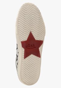 Bílá podrážka tenisky s klikatým vzorem a velkou červenou hvězdou jako akcentem s vyraženým logem. Hvězda umístěná na středové části.