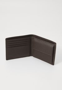 Portefeuille en cuir marron avec une finition texturée, plusieurs emplacements pour cartes, une poche intérieure et des accents cousus. Design bi-fold compact.