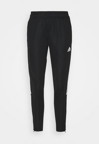 Černé sportovní kalhoty s elastickým pasem. Mají bílé boční pruhy a zúžené nohavice. Vyrobené z hladkého, pružného materiálu.