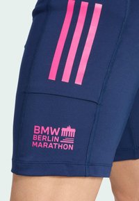 Shorts de sport bleu marine avec des rayures roses Adidas et le logo "BMW Berlin Marathon" avec le symbole de la Porte de Brandebourg sur la cuisse.