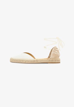 White espadrille flat with braided jute sole, woven textured heel counter, and wrap-around ankle ties on a white background.