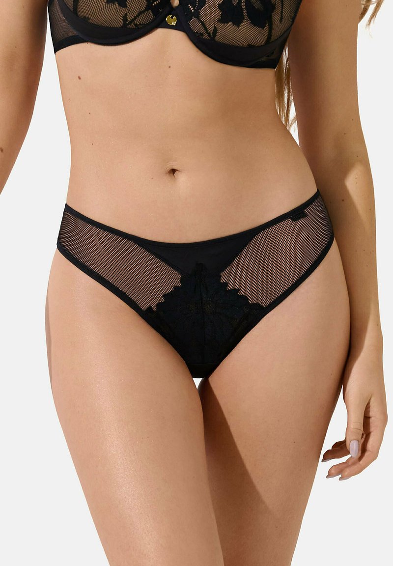 Culotte en dentelle noire et en maille avec un motif floral, dotée d'une taille basse et d'une texture lisse, conçue pour le confort et le style.