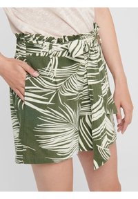 Pantaloni corti verdi con motivo a foglie bianche, cintura in tessuto con nodo, vita arricciata e tasche laterali. Realizzati in materiale leggero.
