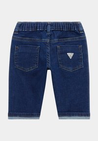 Pant shorts in denim blu scuro con vita elastica, due tasche posteriori e un piccolo logo del marchio sulla tasca destra. Orli rifiniti.