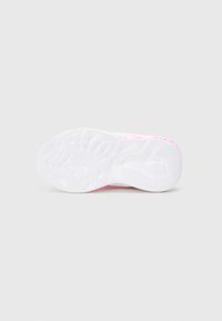 Suela blanca de una zapatilla con un patrón de agarre texturizado; toques de color rosa cerca del talón y en la parte inferior, con sutiles elementos de marca.