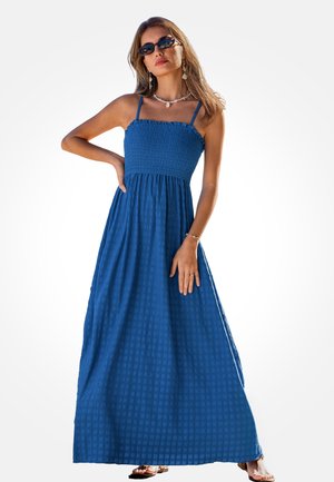Maxi-jurk van gestructureerde blauwe stof met een gerimpeld lijfje, dunne bandjes en een vloeiende silhouet. Lange lengte en subtiele ruches aan de bovenkant.