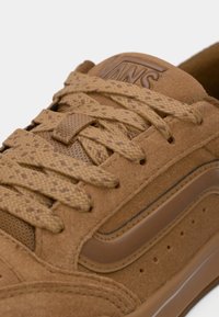 Sneaker in suede marrone con lacci testurizzati, pannello laterale perforato e un accentuazione sintetica liscia. Logo impresso sulla linguetta.