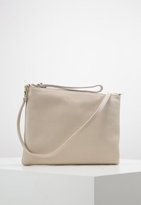 Borsa clutch in pelle beige con superficie strutturata, chiusura superiore con zip e una sottile tracolla regolabile, caratterizzata da un design rettangolare minimalista.