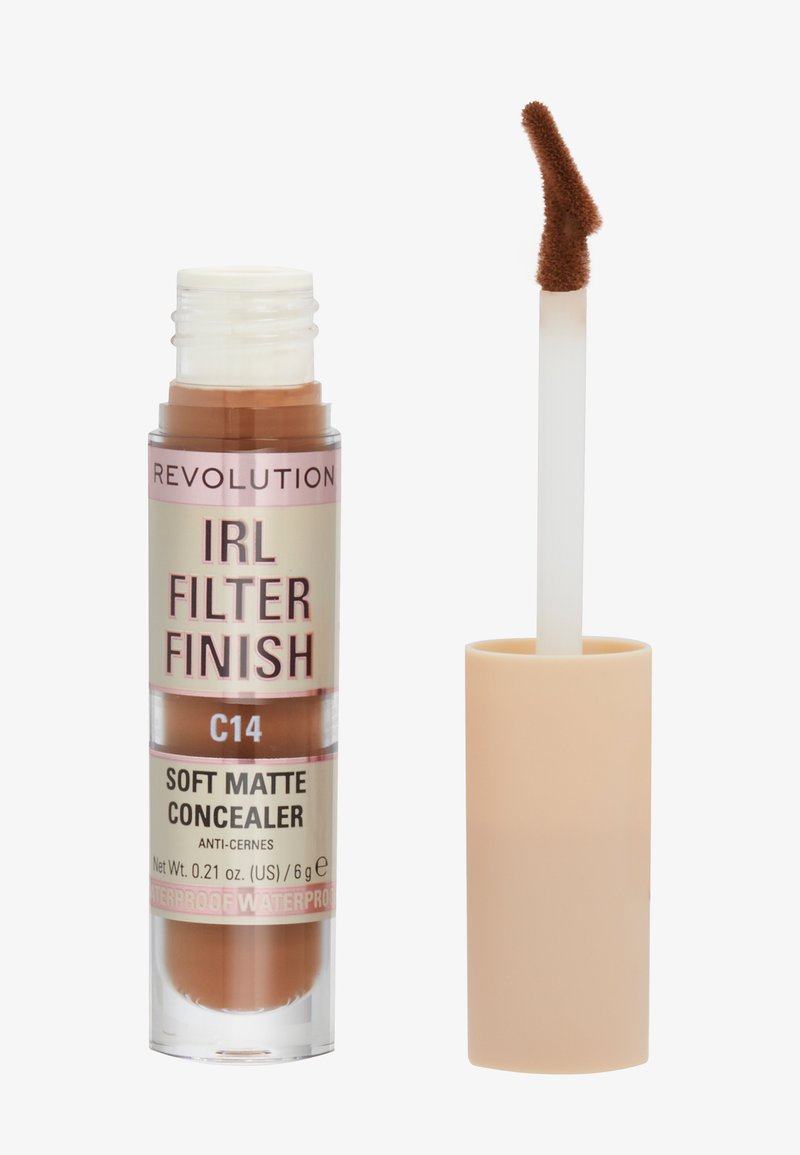 Correcteur mat doux dans un flacon cylindrique transparent avec un capuchon beige. L'applicateur a une pointe floue précise. La couleur est marron moyen (C14).
