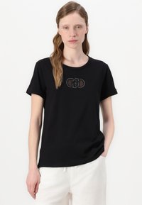 T-shirt nera in cotone con maniche corte, scollatura tonda, caratterizzata da una grafica decorativa al centro. Texture liscia e vestibilità comoda.