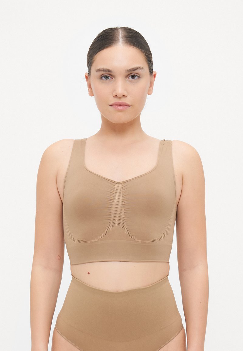 Set di bralette beige e slip a vita alta realizzato in tessuto morbido. Presenta un colletto arrotondato, spalline larghe e dettagli cuciti.