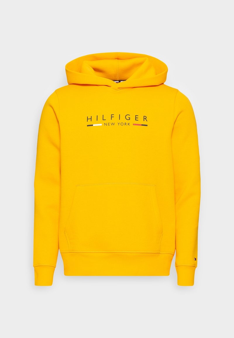 Yellow hoodie made of soft cotton. Features a kangaroo pocket, drawstring hood, and printed "HILFIGER NEW YORK" logo in navy and red.