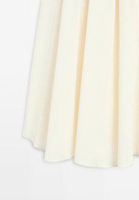 Off-white fabric with subtle vertical stripes, pleated with soft folds and a smooth texture, forming a flowing drape.