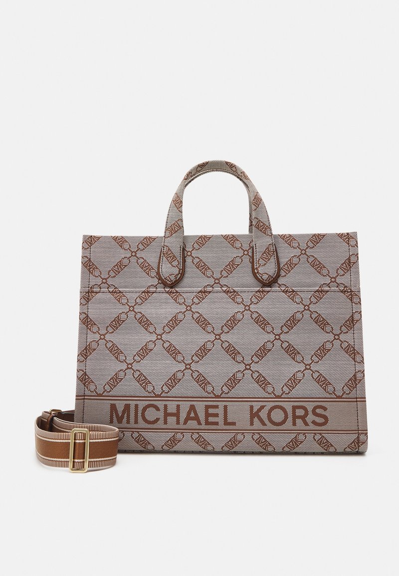 Brun og beige mønstret Michael Kors shoppertaske med to håndtag og en aftagelig skulderrem med striber på hvid baggrund.