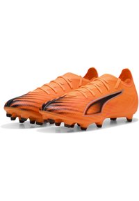 Scarpe da calcio arancioni brillanti con una tomaia testurizzata, accenti neri e chiusura con lacci tradizionale. Suola in gomma chiodata per trazione.