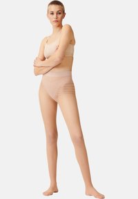 Bralette senza cuciture di colore nudo e slip trasparenti a vita alta. Gli slip presentano dettagli a strisce orizzontali. Materiale morbido e elasticizzato.