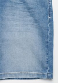Hellblauer Jeansrock mit glatter Textur, geradem Schnitt und einem Saum, der am unteren Rand mit einer einfachen Stichverzierung abgeschlossen ist.