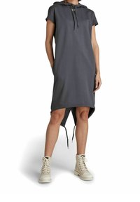 Mörkgrå klänning med huva och korta ärmar, med en hög-låg nederdel, dragsko-detaljer, parat med ljusa snörstövlar.