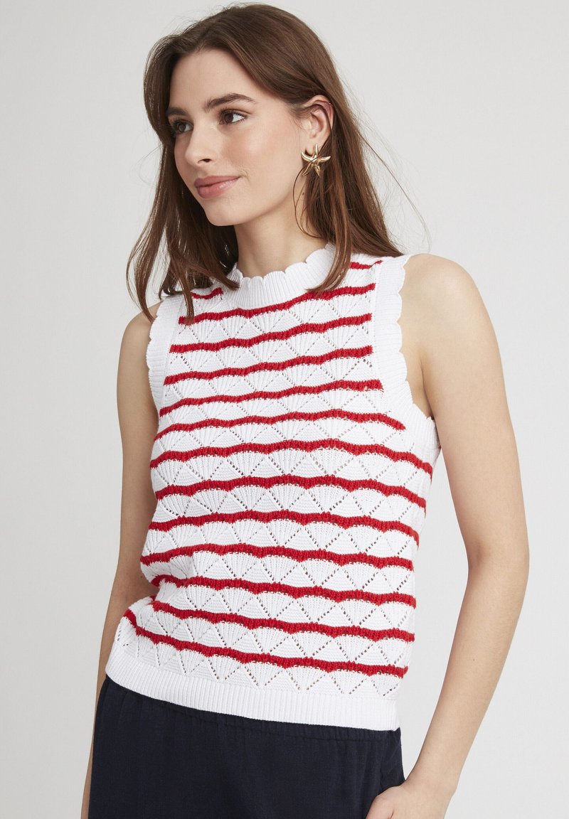 Haut sans manches en tricot rouge et blanc avec un col en dentelle et un motif ondulé. Tissu texturé avec une coupe ajustée.