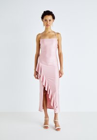 Ροζ σατέν φόρεμα με τετράγωνη λαιμόκοψη, ρυθμιζόμενες τιράντες και πλαϊνό βολάν. Εφαρμοστό σιλουέτα με σκίσιμο μέχρι το μηρό.