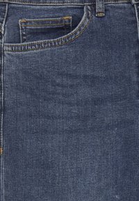 Vaqueros de denim en azul oscuro con un corte estándar, que cuentan con un bolsillo frontal y costuras visibles en un tono dorado contrastante.
