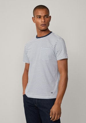 Hvid stribet t-shirt med marineblå vandrette linjer, ribbet marineblå krave, korte ærmer og lille broderet logo ved kanten.