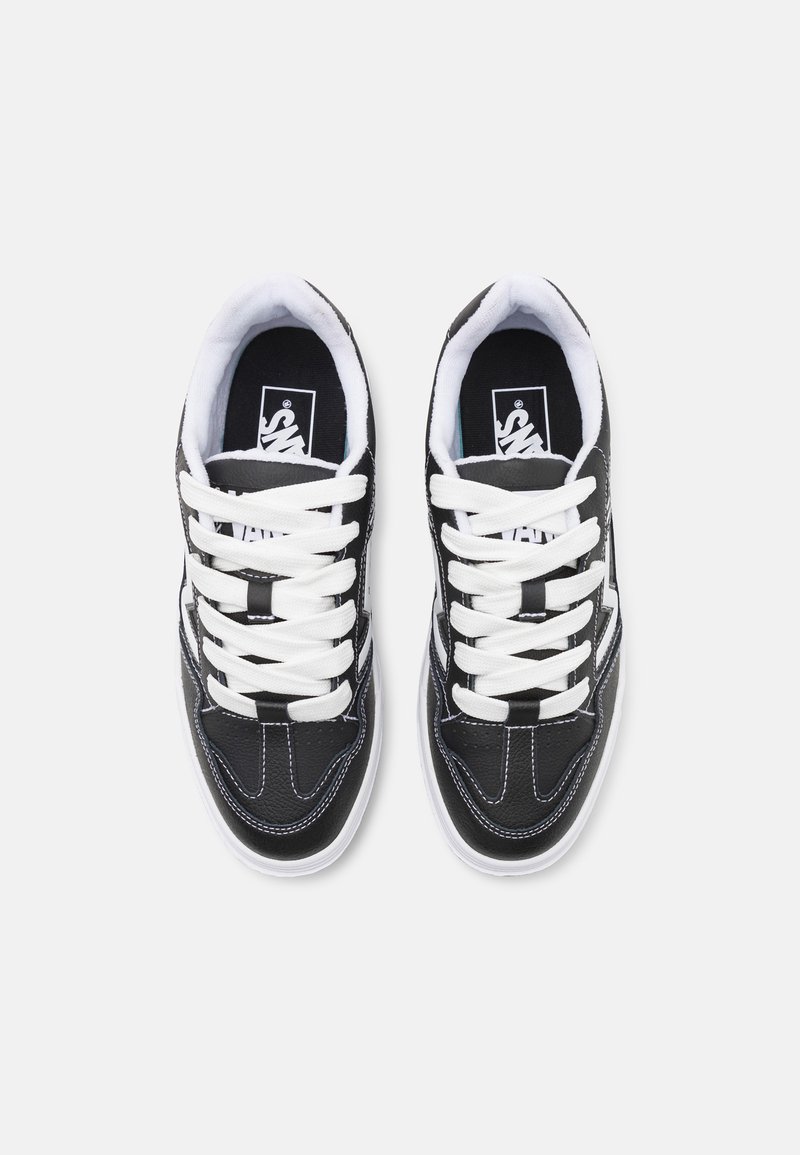 Baskets noir et blanc avec une tige en cuir texturé, lacets blancs, couture contrastée et semelle intérieure rembourrée, portant un logo sur la languette.