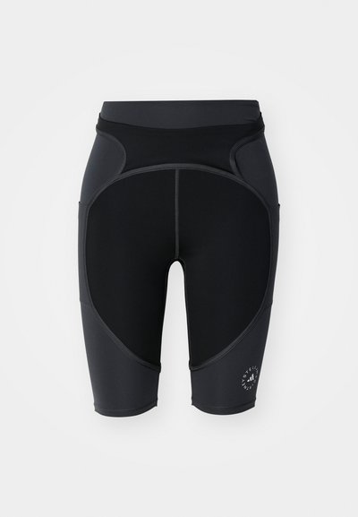 Black cycling shorts made of stretchy fabric, featuring a smooth texture, panel accents, and logo detail on the lower side.