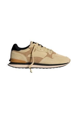 Baskets en suède beige avec des accents noirs, design à lacets, semelle matelassée et superpositions texturées. Comprend une languette de talon contrastante en brun.