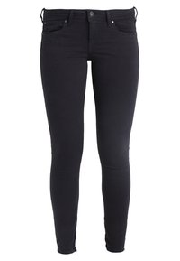Black skinny jeans made of denim, featuring a high waistband, five-pocket design, and minimal stitching detail near the zipper.