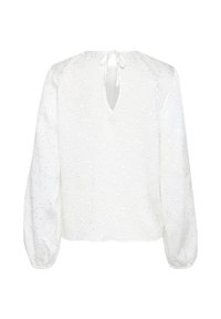 Blouse blanche avec un empiècement en dentelle texturée, décolleté en V et longues manches bouffantes. Présente une fermeture à nouer au dos.