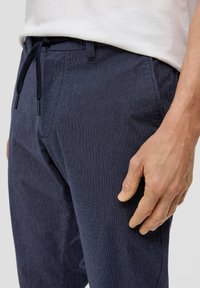Marine gestreifte Hosen aus leichtem Stoff, mit einem Gummizugbund, seitlichen Taschen und einer glatten Textur.