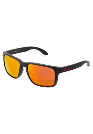 Lunettes de soleil en plastique noir avec des verres miroités orange. Verres plats et rectangulaires, avec une monture élégante arborant un petit logo sur la branche.