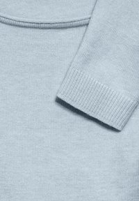 Maglione azzurro chiaro realizzato in morbido tessuto a maglia, con collo e polsini ribattuti. Texture liscia con un design semplice e minimale.