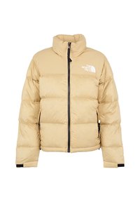 Beige pufferjack met hoge kraag, ritssluiting aan de voorkant en logo op de borst. Kenmerkt een gestikt geweven patroon en elastische manchetten.