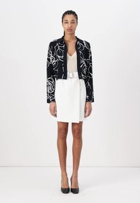Μαύρο κοντό σακάκι με λευκό floral σχέδιο, μπεζ τοπ, λευκή μίνι φούστα και μαύρες ψηλές γόβες. Λείο υφή; εφαρμοστή σχεδίαση.