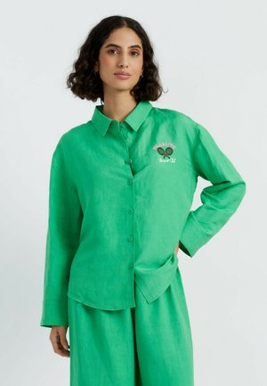 Groene linnen overhemd met knopen, voorzien van een gekraagde hals en lange mouwen, geborduurd met een tennismotief. Glad textuur met een relaxte pasvorm.