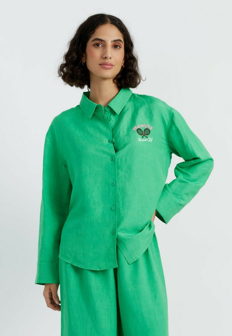 Groene linnen overhemd met knopen, voorzien van een gekraagde hals en lange mouwen, geborduurd met een tennismotief. Glad textuur met een relaxte pasvorm.