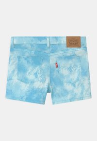 Shorts de mezclilla en un patrón de tie-dye azul claro, con bolsillos traseros curvados, una etiqueta de cuero con la marca y costuras en contraste.