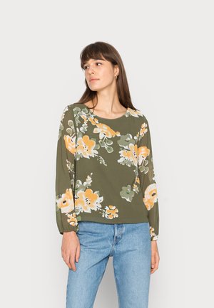 Blusa com padrão floral em verde oliva com flores amarelas e brancas. Possui mangas longas e um decote redondo. O tecido parece suave.