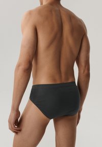 Szare męskie kąpielówki o gładkiej fakturze, elastycznym pasie i minimalistycznym designie, widok z tyłu, ukazujący dopasowanie pasa.