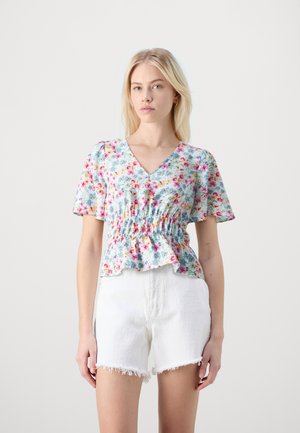 Blomstrete v-halsbluse med korte pufferm, har smocket midje og volangkant. Lys blå stoff med blandede små blomstermønster.