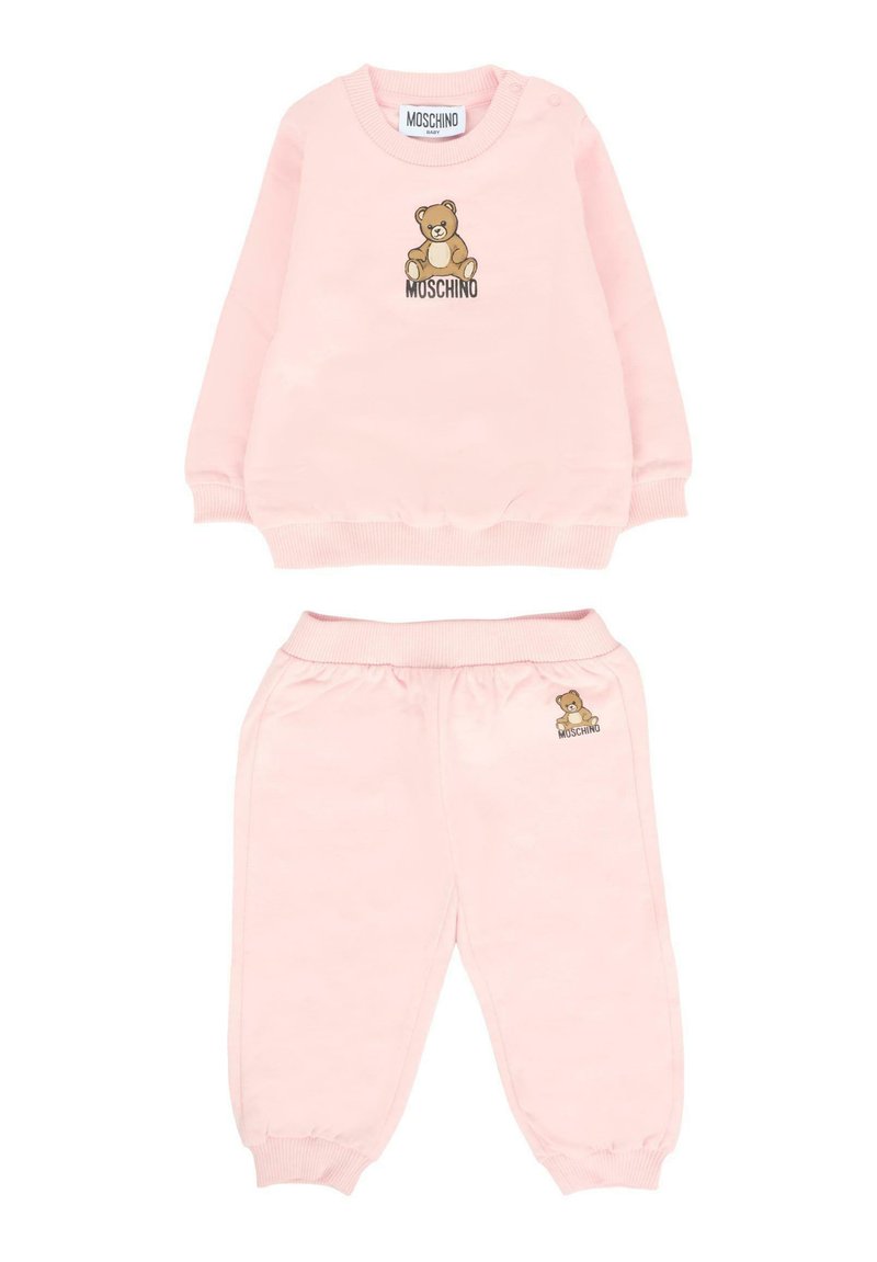 Miękka, różowa bluza dla niemowląt oraz zestaw spodni z grafiką misia i logo "Moschino" z przodu bluzy oraz na kieszeni spodni.