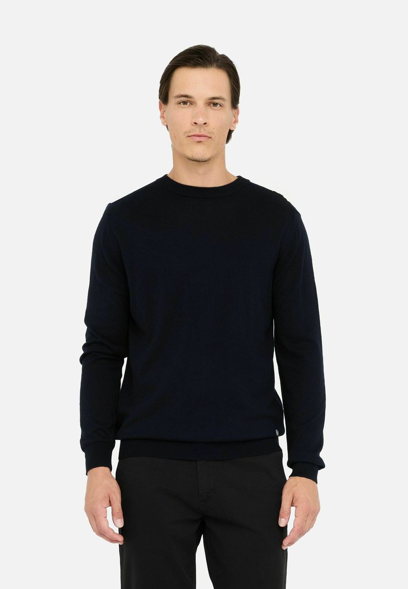 Maglione a maglia blu navy con scollatura rotonda e maniche lunghe. Presenta un orlo e polsini aderenti, realizzato in un tessuto morbido e strutturato.