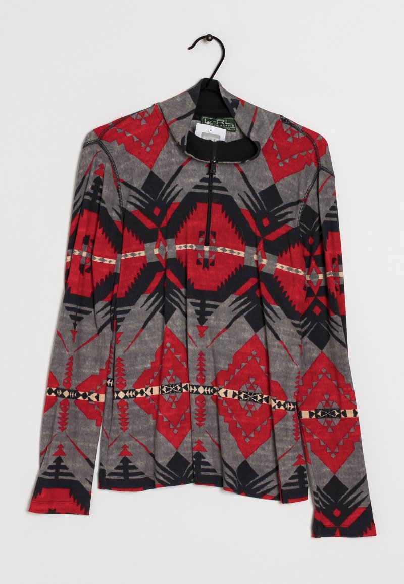 Maglia a maniche lunghe con colletto con zip, caratterizzata da uno sfondo grigio con motivi geometrici rossi, neri e beige e un tessuto testurizzato.