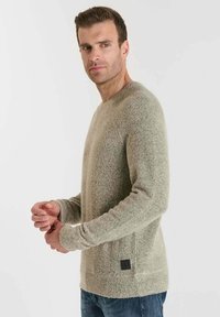Hellgrauer Strickpullover mit einer strukturierten Oberfläche, Rundhalsausschnitt und langen Ärmeln. Verfügt über ein kleines schwarzes Logopatch an der Seite.