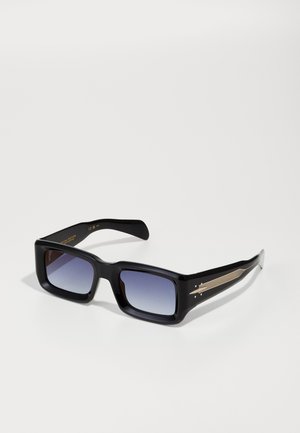Schwarze quadratische Sonnenbrille mit Verlaufslinsen, die ein goldfarbenes Akzentdesign an den Bügeln und ein glattes Kunststoffgestell aufweist.