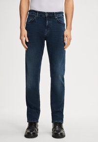 Jeans in denim blu scuro con un taglio dritto classico, dotati di tasche frontali, chiusura con zip e un leggero sbiadimento sulle cosce.