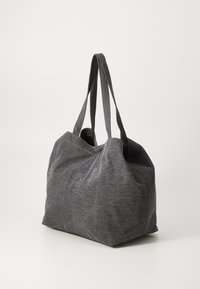 Grå stoff toteveske med en myk, teksturert overflate; har to robuste håndtak og en romslig, avrundet form. Ingen synlig maskinvare.